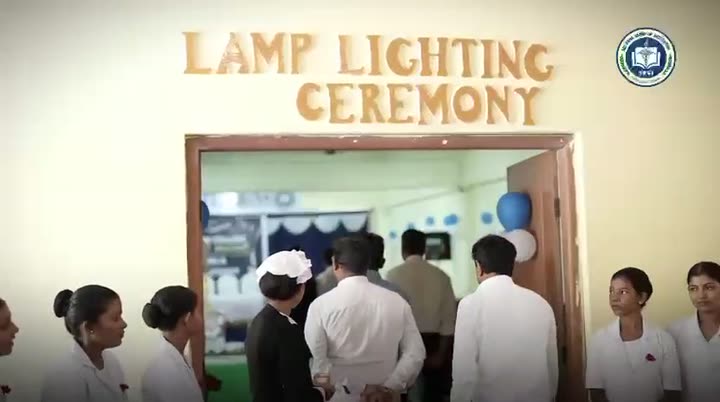 A garlanded portrait of Florence Nightingale, a speaker addressing the audience, and rows of lit lamps during the nursing lamp lighting ceremony