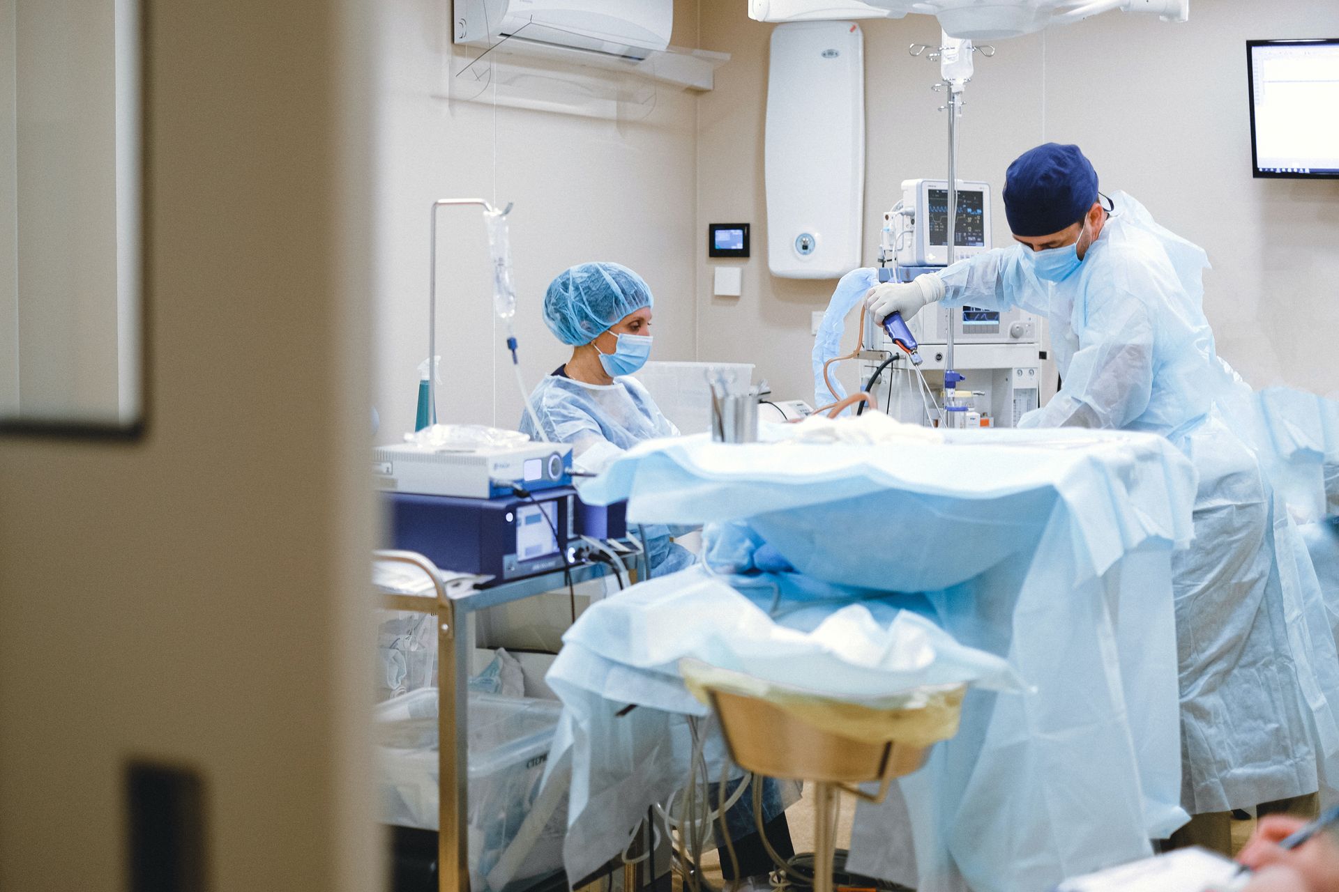 A surgical team in gowns and masks working in an operating theatre